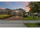 Charming home exterior with manicured lawn, brick driveway, and a two-car garage at 2571 Yellow Brick Rd, St Cloud, FL 34772