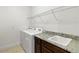 Bright laundry room with granite counters, sink, and modern washer and dryer beneath wire shelving at 2571 Yellow Brick Rd, St Cloud, FL 34772