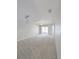 An empty living room boasts neutral paint, carpet flooring, and sliding glass doors to a balcony at 2816 Club Cortile Cir # A, Kissimmee, FL 34746