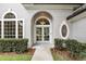 Elegant arched entryway with double glass doors, decorative sidelights, and manicured landscaping at 2890 Wild Ginger Ct, Winter Park, FL 32792