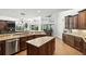 Open-concept kitchen with stainless steel appliances, an island, and seamless access to outdoor dining with pool view at 2890 Wild Ginger Ct, Winter Park, FL 32792