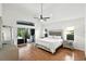 Serene main bedroom featuring wood floors, a ceiling fan, and sliding glass doors to the patio at 2890 Wild Ginger Ct, Winter Park, FL 32792
