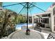Outdoor dining area with umbrella by the screened-in pool, providing shade and a view at 2890 Wild Ginger Ct, Winter Park, FL 32792