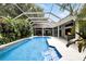 Beautiful screened-in pool with an adjacent outdoor living area and fireplace, perfect for gatherings at 2890 Wild Ginger Ct, Winter Park, FL 32792
