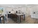 Open kitchen boasts white cabinets, stainless steel appliances, large island, and wood floors at 3004 Water Clover Ct, Apopka, FL 32712