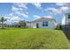 Expansive backyard with green grass, black metal fence, and bright white house at 3110 Areca Ave, New Smyrna Beach, FL 32168