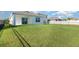 Large, green backyard with a black metal fence and bright sky backdrop at 3110 Areca Ave, New Smyrna Beach, FL 32168