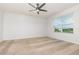 Bright bedroom featuring a ceiling fan and a window offering neighborhood views at 3110 Areca Ave, New Smyrna Beach, FL 32168
