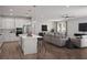 Bright, open floor plan with modern kitchen featuring a center island and sleek stainless steel appliances at 3492 Lemon Button Ter, Apopka, FL 32712