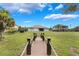 Scenic backyard with a charming wooden walkway leading towards the lake, lush greenery at 3531 Oriskany Dr, Orlando, FL 32820