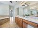 Bathroom with double vanities, a soaking tub, and neutral tile flooring that complements the natural light at 3531 Oriskany Dr, Orlando, FL 32820