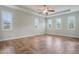 A spacious bedroom with lots of natural light and light hardwood floors in a modern herringbone pattern at 3531 Oriskany Dr, Orlando, FL 32820