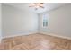 A serene, light-filled bedroom with a herringbone floor and a single window with white shutters at 3531 Oriskany Dr, Orlando, FL 32820