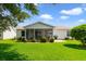 Spacious backyard with a screened-in porch, well-kept lawn and manicured shrubs at 3531 Reston Dr, The Villages, FL 32162