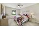 Bedroom with wood-look flooring, ceiling fan, and bright window offering natural light at 3531 Reston Dr, The Villages, FL 32162