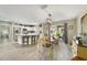 Bright dining area with modern lighting, a view to the backyard, and an adjacent kitchen space at 3531 Reston Dr, The Villages, FL 32162