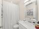 Well-lit bathroom featuring a shower with a white curtain and a sleek vanity with a stylish mirror at 3866 Cabo Rojo Dr, St Cloud, FL 34772