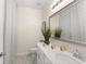 Bright bathroom featuring white cabinets, light countertops, decorative mirror, and tiled floors at 3866 Cabo Rojo Dr, St Cloud, FL 34772
