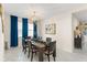 Elegant dining room featuring a modern light fixture, rich wooden table and blue curtains at 3866 Cabo Rojo Dr, St Cloud, FL 34772