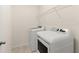 Well-lit laundry area featuring modern washer, dryer, and convenient overhead shelving at 3866 Cabo Rojo Dr, St Cloud, FL 34772