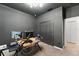 Functional office space featuring a dark-colored wall, modern workstation setup and neutral-toned carpet at 3866 Cabo Rojo Dr, St Cloud, FL 34772