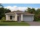 Charming single-story home features a two-car garage, neutral paint, and landscaped front yard with lush green grass at 4674 Coral Harbour Rd, Kissimmee, FL 34758