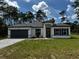 Beautiful single-story home with a gray driveway, black trim, and a well-manicured lawn at 5119 Sw 165Th Pl, Ocala, FL 34473