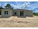 New home construction featuring sliding glass doors, a modern design, and a spacious sand-covered backyard at 5381 Sw 128Th Street Rd, Ocala, FL 34473
