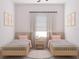 Charming bedroom with two twin beds, soft lighting, and decoratively framed pictures creating a cozy and inviting atmosphere at 5381 Sw 128Th Street Rd, Ocala, FL 34473