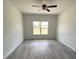 Empty bedroom featuring gray wood-look tile floors, neutral walls, and a ceiling fan at 5381 Sw 128Th Street Rd, Ocala, FL 34473
