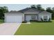 Charming single-story home features a two-car garage, well-manicured lawn and simple, colorful landscaping at 5381 Sw 128Th Street Rd, Ocala, FL 34473
