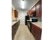 Kitchen with black appliances, tile backsplash, and wood cabinets at 6434 Cava Alta Dr # 401, Orlando, FL 32835