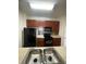 Kitchen with black appliances, tile backsplash, and wood cabinets at 6434 Cava Alta Dr # 401, Orlando, FL 32835