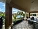Covered patio with tiled flooring showcases an inviting view of the lush pool and landscape at 6434 Cava Alta Dr # 401, Orlando, FL 32835