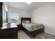 Cozy bedroom with dark wood furniture, including a dresser and bed frame, complemented by a bright window at 6458 Pine Warbler Way, St Cloud, FL 34771
