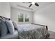 Bright bedroom featuring a decorative duvet, two windows, and a ceiling fan at 6458 Pine Warbler Way, St Cloud, FL 34771