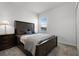 Cozy bedroom showcasing neutral carpet, a window, nightstand and a lamp at 6458 Pine Warbler Way, St Cloud, FL 34771