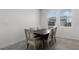 Elegant dining room with a dark wood table and seating for six near bright windows at 6458 Pine Warbler Way, St Cloud, FL 34771