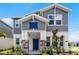 Charming two-story home featuring stone accents, a blue front door, and beautifully landscaped front yard at 6458 Pine Warbler Way, St Cloud, FL 34771