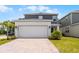 Attractive two-story home featuring a wide driveway, lush lawn, and a modern two-car garage at 6458 Pine Warbler Way, St Cloud, FL 34771