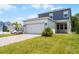 Charming two-story home featuring a wide driveway, lush lawn, and a modern two-car garage at 6458 Pine Warbler Way, St Cloud, FL 34771