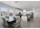 Open concept kitchen with white cabinets, island seating and a dining area adjacent to windows at 6458 Pine Warbler Way, St Cloud, FL 34771