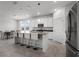 Bright and airy kitchen with stainless steel appliances, white cabinets, gray counters, and an island bar with seating at 6458 Pine Warbler Way, St Cloud, FL 34771