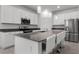 Modern kitchen featuring stainless steel appliances, white cabinets, gray countertops, and a large island with seating at 6458 Pine Warbler Way, St Cloud, FL 34771