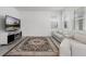 Bright living room featuring a modern fireplace and comfortable white leather sectional couch at 6458 Pine Warbler Way, St Cloud, FL 34771