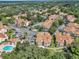 Aerial view of condo complex, surrounded by lush greenery, features a community pool, and ample parking at 698 Roaring Dr # 382, Altamonte Springs, FL 32714