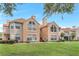 Condo exterior featuring well-manicured lawn, beige siding, and a staircase leading to the upper levels at 698 Roaring Dr # 382, Altamonte Springs, FL 32714