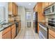 Galley kitchen featuring tile floors, dark countertops and stainless steel appliances at 698 Roaring Dr # 382, Altamonte Springs, FL 32714