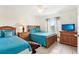 Bedroom with twin beds, wooden furniture, and bright natural light from the window at 8801 Crayson Ct, Kissimmee, FL 34747