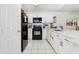 Well-lit kitchen featuring white cabinetry, black appliances, and a modern design at 8801 Crayson Ct, Kissimmee, FL 34747